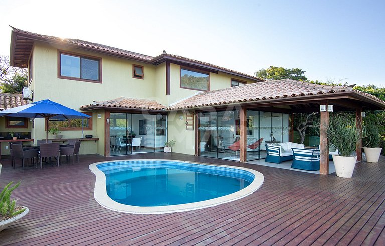 Casa com quatro suítes, sala de tv, piscina e churrasqueira.