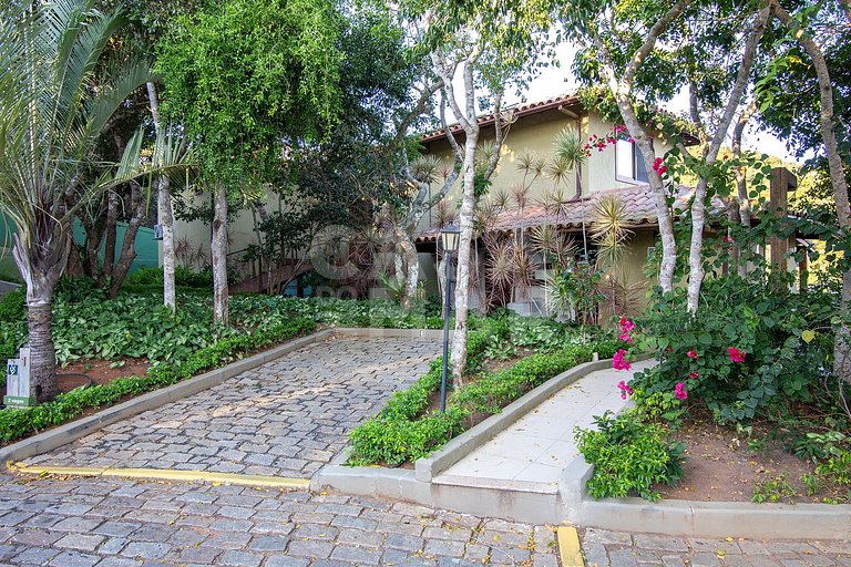 Casa com quatro suítes, sala de tv, piscina e churrasqueira.