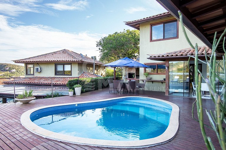 Casa com quatro suítes, sala de tv, piscina e churrasqueira.