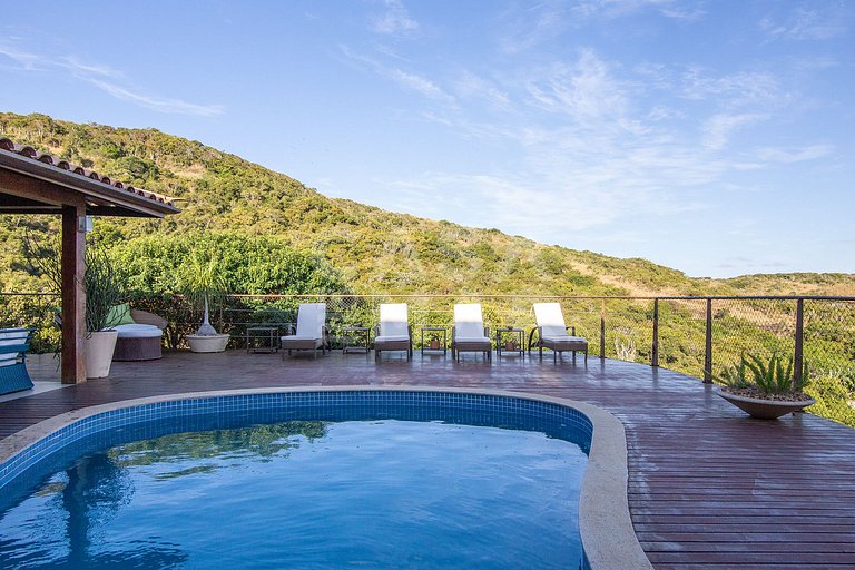 Casa com quatro suítes, sala de tv, piscina e churrasqueira.