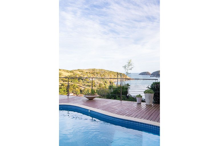 Casa com quatro suítes, sala de tv, piscina e churrasqueira.