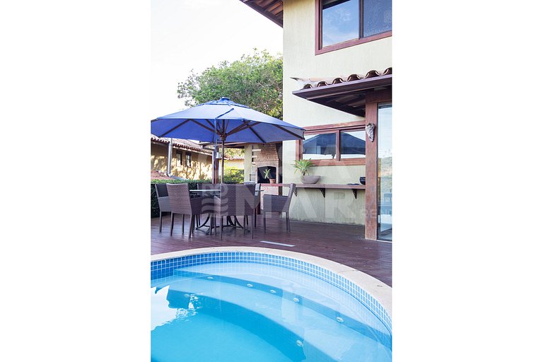 Casa com quatro suítes, sala de tv, piscina e churrasqueira.