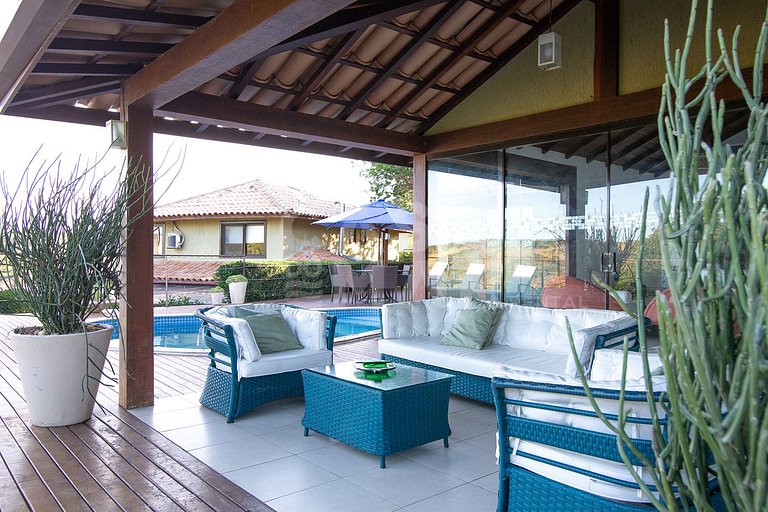 Casa com quatro suítes, sala de tv, piscina e churrasqueira.