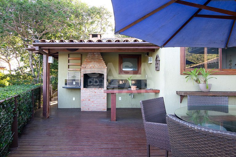 Casa com quatro suítes, sala de tv, piscina e churrasqueira.