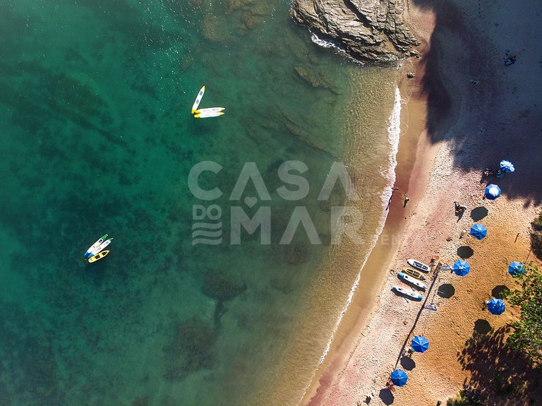 Casa com quatro suítes, sala de tv, piscina e churrasqueira.