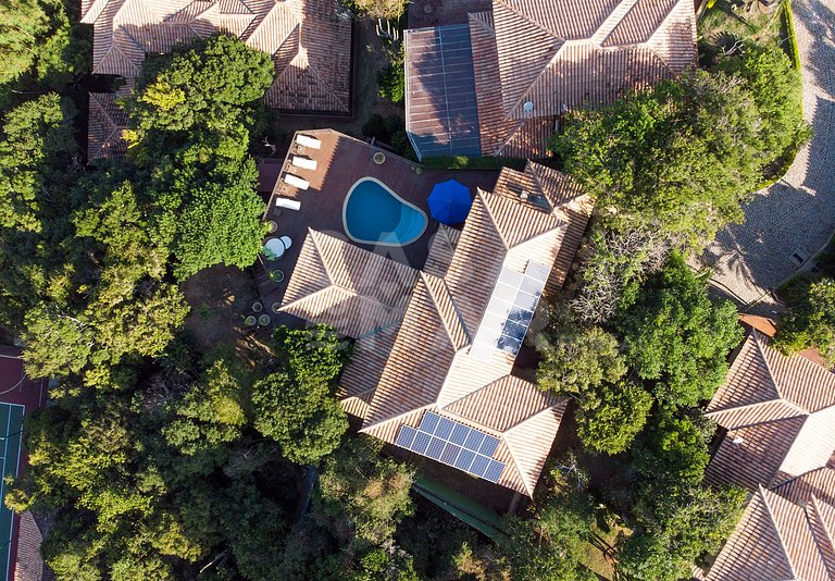 Casa com quatro suítes, sala de tv, piscina e churrasqueira.