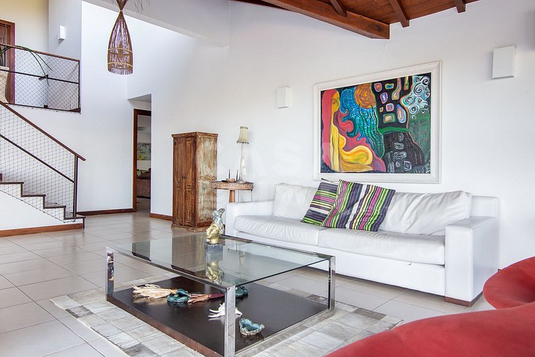 Casa com quatro suítes, sala de tv, piscina e churrasqueira.