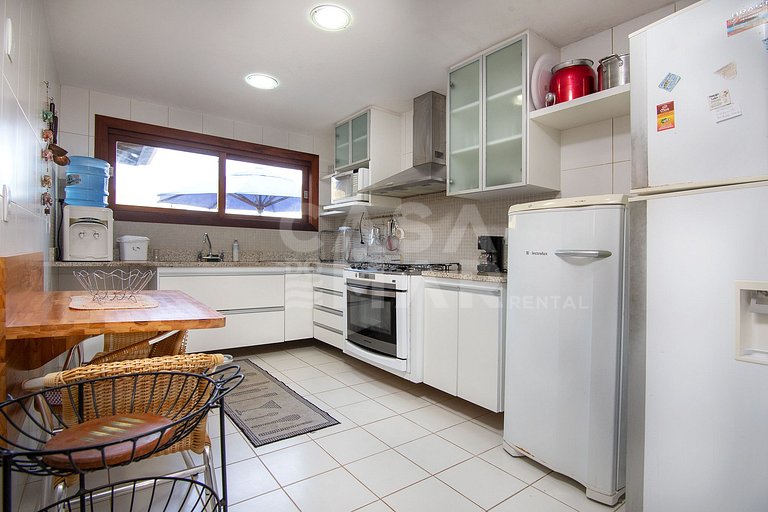 Casa com quatro suítes, sala de tv, piscina e churrasqueira.