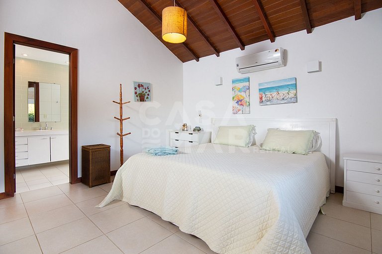 Casa com quatro suítes, sala de tv, piscina e churrasqueira.