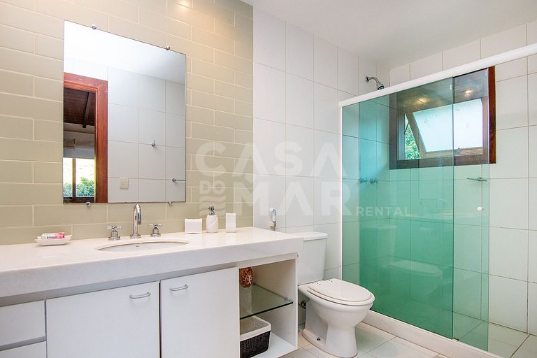 Casa com quatro suítes, sala de tv, piscina e churrasqueira.
