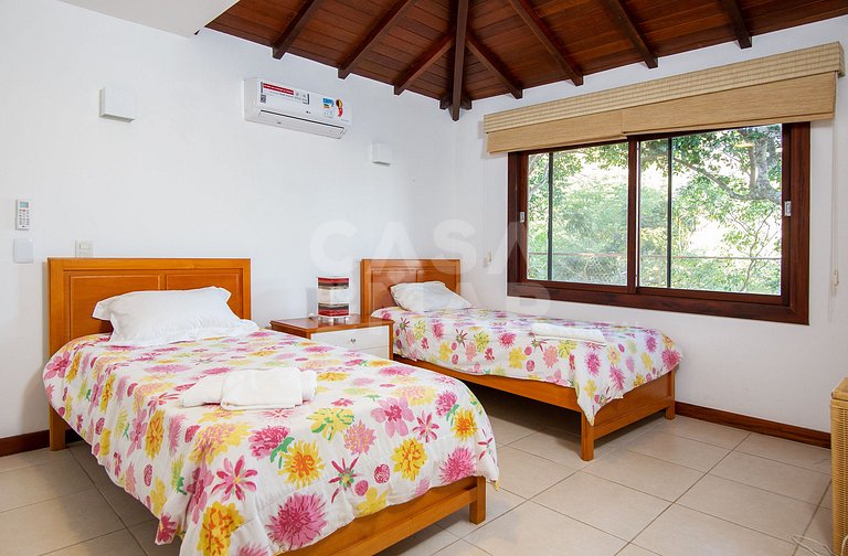 Casa com quatro suítes, sala de tv, piscina e churrasqueira.