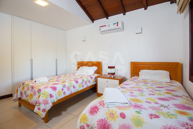 Casa com quatro suítes, sala de tv, piscina e churrasqueira.